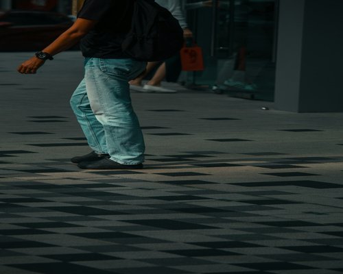 Person enjoying a leisurely stroll on a sunny city pavement